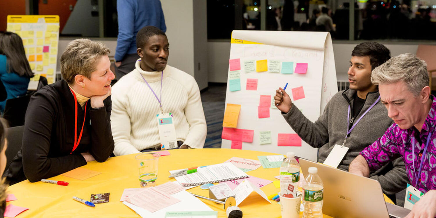 Idea makers gather at a table with post-its and conversation