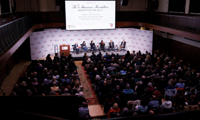 An aerial shot of the event The American Revolution: Lessons for the 250th, six speakers are on the stage and the seats are full. 