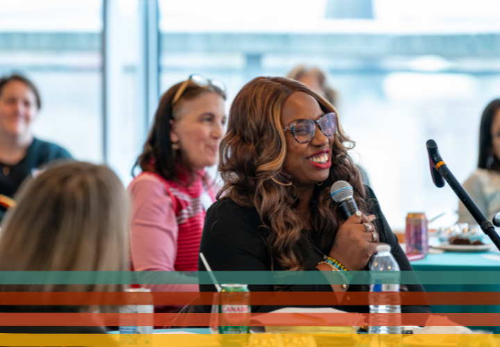 Student with a walking cane smiles at the mic to ask questions. 