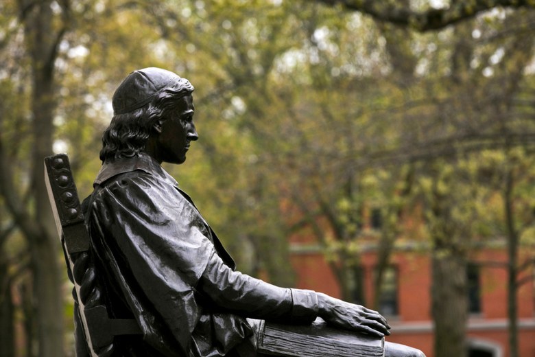 A statue of John Harvard on Harvard campus.
