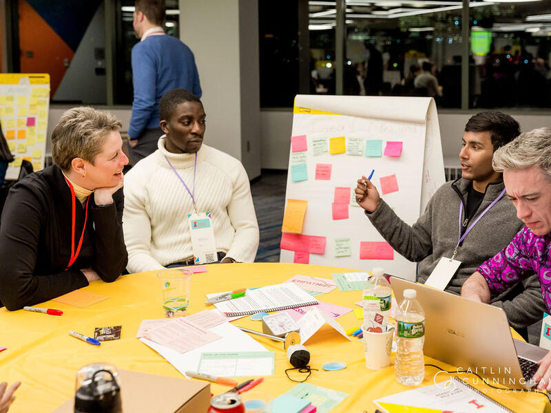 Idea makers gather at a table with post-its and conversation