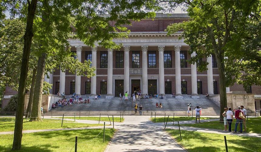 Exterior of Widener Library with community members sitting on the steps.
