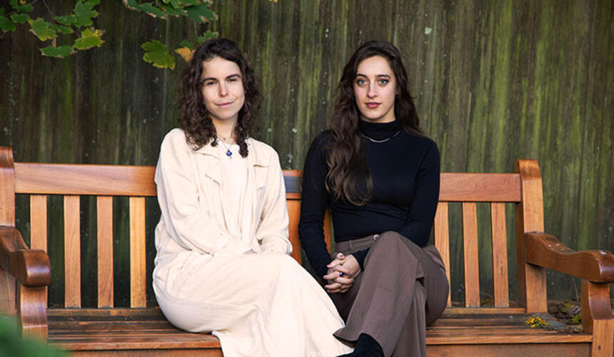 Paula Ortiz and Lia Pikus sitting on a bench.